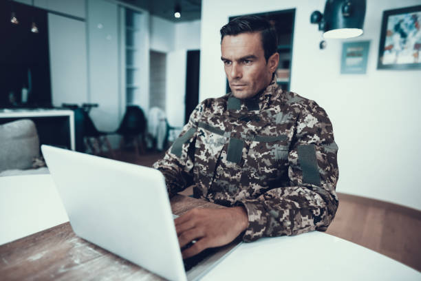 istock Handsome Military Man Works at Table on Laptop 1051655942