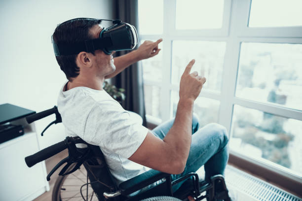 istock Disabled Man Enjoys VR Goggles with Hands Up 1051656028