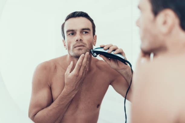 riflesso speculare dell'uomo lavarsi i denti in bagno - shaving men electric razor reflection foto e immagini stock