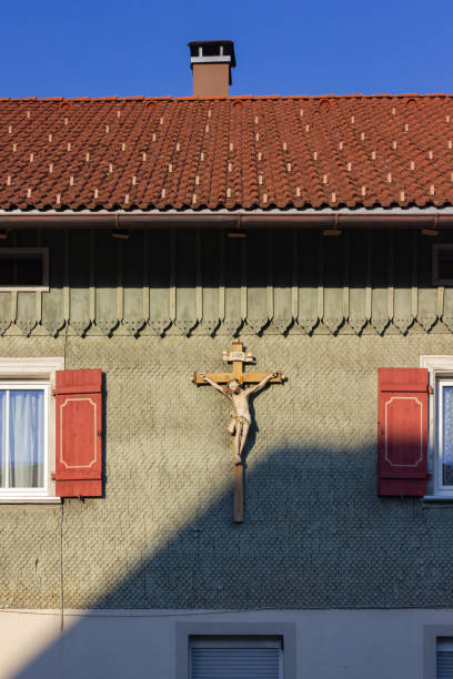 istock wooden green facade with crucifix and red color shutter 1051658578