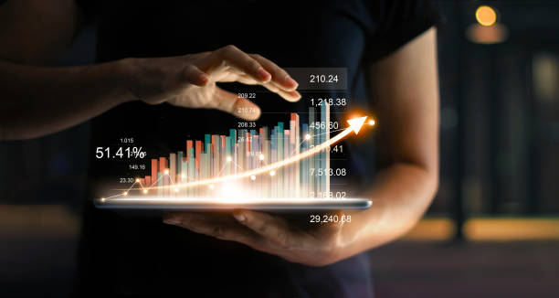 homme d’affaires détenant tablet et montrant un hologramme virtuel grandissant de statistique, graphique et tableau avec flèche sur fond sombre. marchés boursiers. concept croissance, rabotage et stratégie d’entreprise. - business finance and industry photos et images de collection