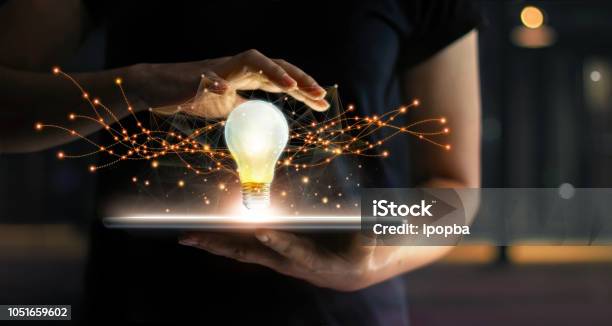 Abstract Innovation Hands Holding Tablet With Light Bulb Future Technologies And Network Connection On Virtual Interface Background Innovative Technology In Science And Communication Concept Stock Photo - Download Image Now