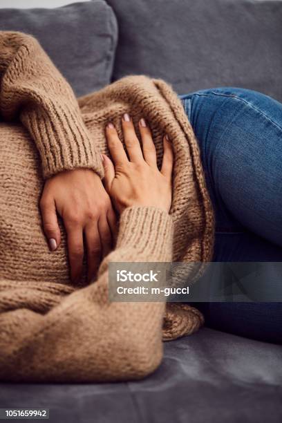 Woman Having Stomach Issues Problems While Lying On The Couch Stock Photo - Download Image Now