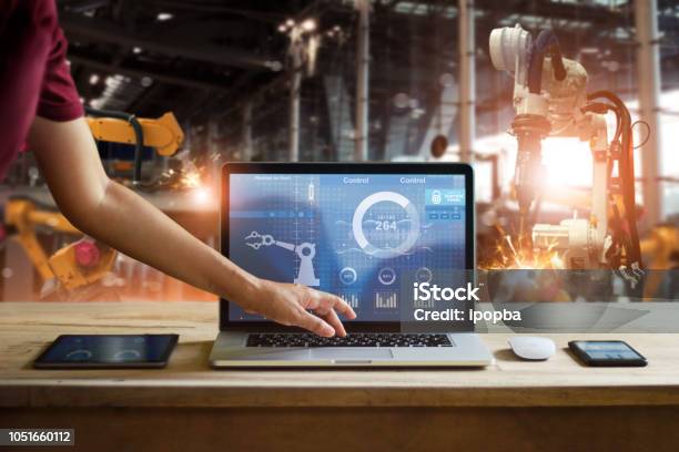 Engineer Touching Laptop Check And Control Welding Robotics Automatic Arms Machine In Intelligent Factory Automotive Industrial With Monitoring System Software Digital Manufacturing Operationindustry 4 Stock Photo - Download Image Now