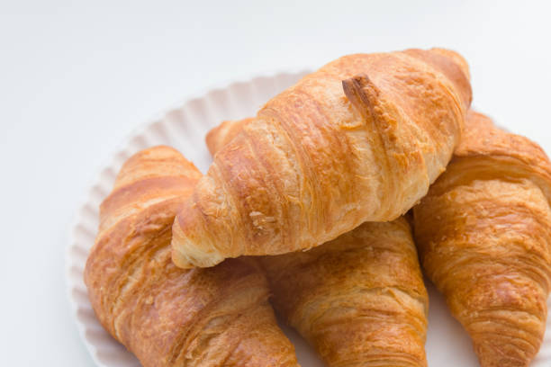 istock Plain croissants on top of each other on the plate, white table background 1051662934