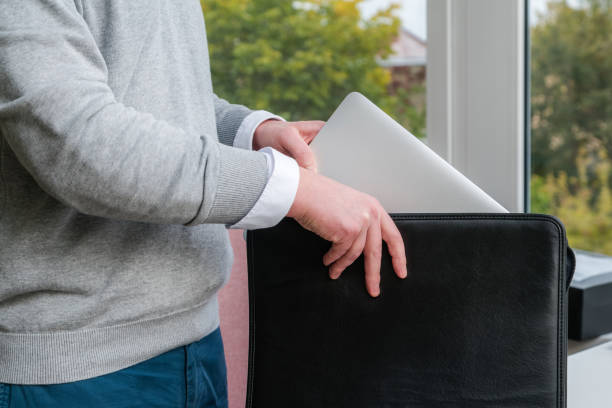 istock Young business man pulling out a laptop out of a leather case at the office 1051663128