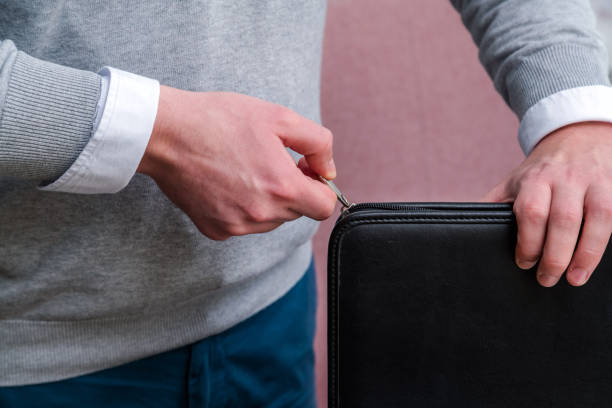 istock Young business man hand pulling a zipper to close a black leather laptop computer case. Working at the office 1051663166