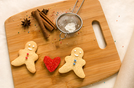 Baked men and red heart cookies on a wooden Board for baking. The concept of love