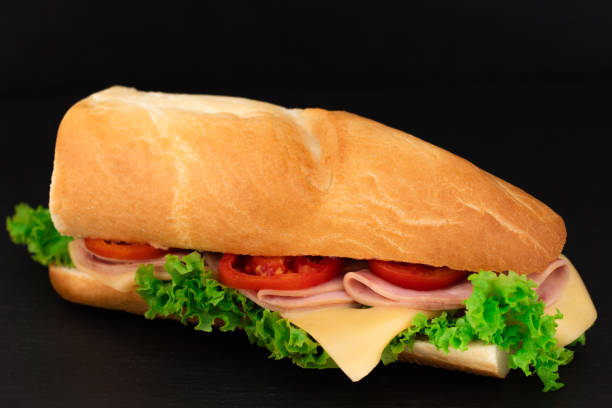 istock Big sandwich with meat and cheese on dark background 1051670592