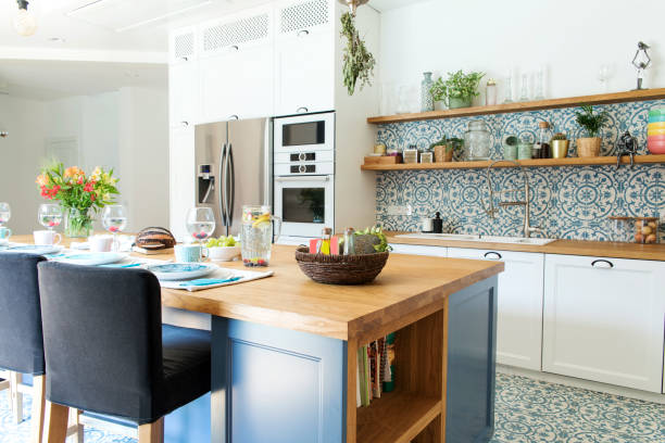 istock Stylish and sunny kitchen interior with accessories, wooden table and plants. Design space. 1051678040