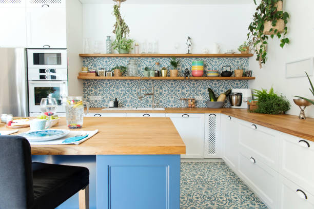 istock Stylish and sunny kitchen interior with accessories, wooden table and plants. Design space. 1051678126