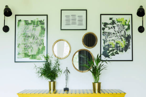 istock Sunny and bright living room with design commode, photo frames and plants. 1051678244