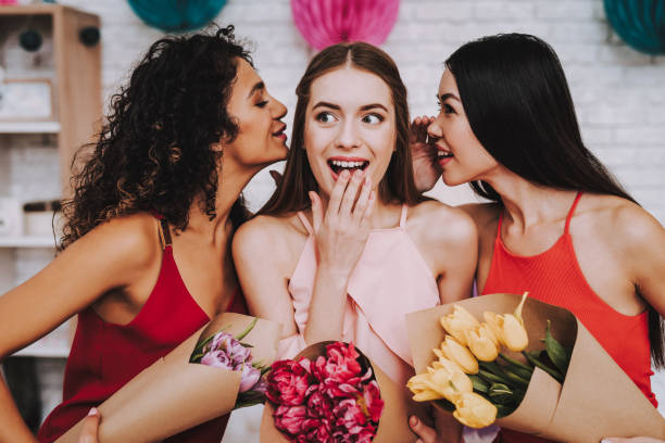 istock Three Happy Women with Bouquets Flowers on March 8 1051678518