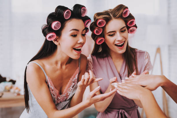 istock Two Emotional Women Watching Manicure Girlfriend. 1051678610