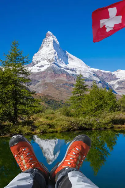 Matterhorn peak with hiking boots in Swiss Alps.