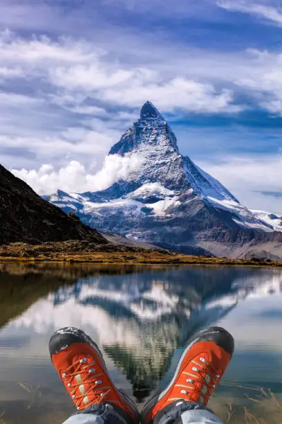Matterhorn peak with hiking boots in Swiss Alps.