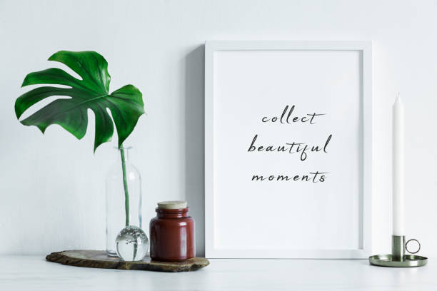 istock Modern and minimalistic composition of mock up photo frame with green tropical leaf, small box and white candle. Stylish concept of mockup frame. 1051686784