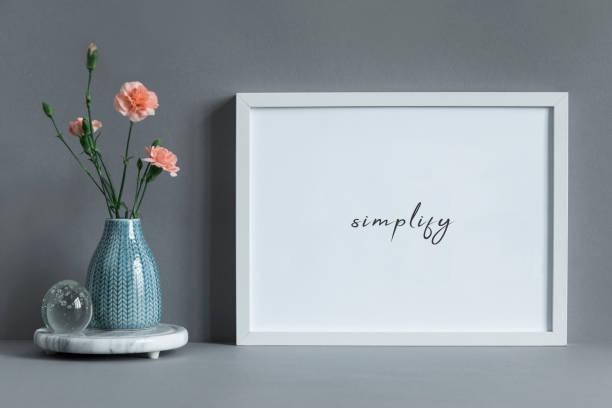 Stylish and minimalistic composition of mock up photo frame with flowers in vase. Modern concept of mockup frame. Modern and minimalistic composition of mock up photo frame. surrounding wall photos stock pictures, royalty-free photos & images