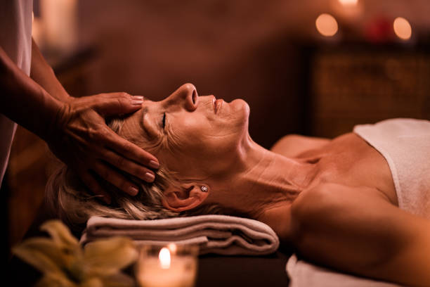 istock Senior woman having head massage by unrecognizable therapist at the spa. 1051690592