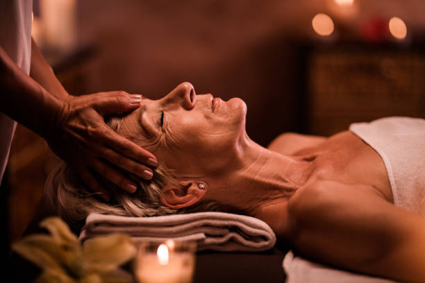 старшая женщина с массажем головы неузнаваемым терапевтом в спа-салоне. - spa treatment head massage health spa healthy lifestyle стоковые фото и изображения