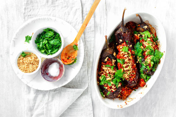 Stuffed eggplant lentils tomatoes nuts wooden table top view