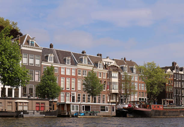 Traditional Dutch architecture houses on coast of Amstel river in Amsterdam