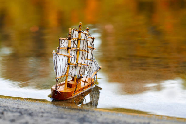Rainbow-Colored Metal Boat with Autumn Leaf at Sunset Beach
