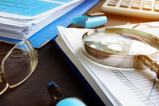 istock Financial analysis and audit. Magnifying glass and report. 1051720136