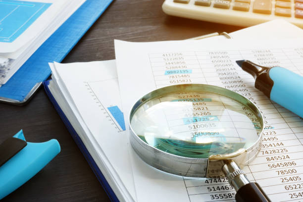 istock Bookkeeping and audit. Magnifying glass and business documents. 1051720174