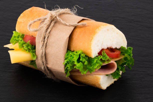 Big sandwich with meat and cheese on dark background
