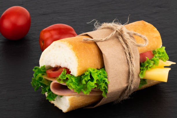 istock sandwich with with ham, cheese, tomatoes, lettuce on over stone 1051720300