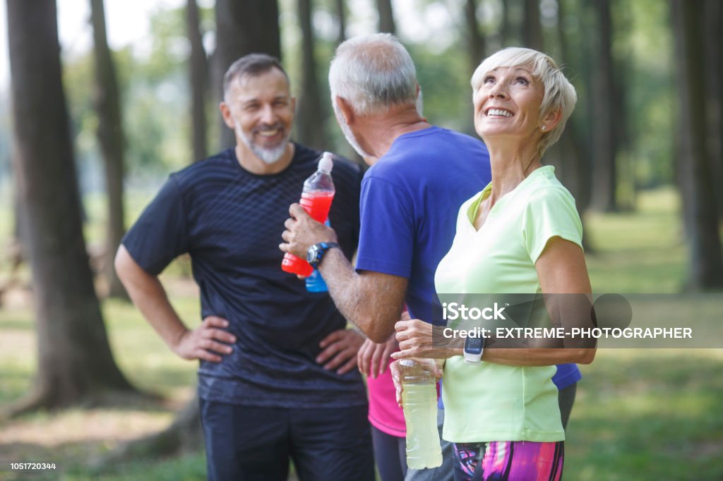 Senior sports people outdoors Group of active senior people resting after exercise in the woods. 60-69 Years Stock Photo