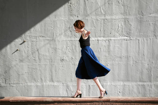 istock young girl posing against a concrete wall, dressed in black, hard light and shadows 1051721324