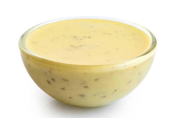 istock Creamy herb dressing in glass condiment bowl isolated on white. 1051721424