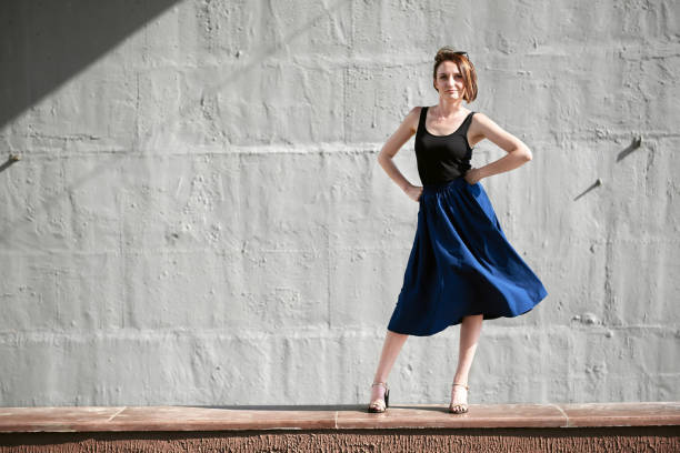 istock young girl posing against a concrete wall, dressed in black, hard light and shadows 1051721498