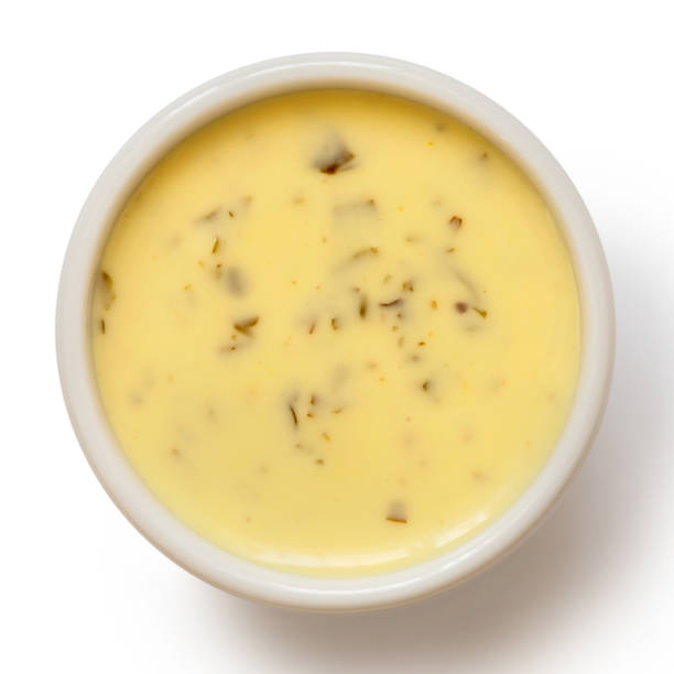 istock Creamy herb dressing in white ceramic condiment bowl isolated on white from above. 1051721532