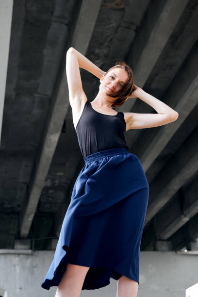 istock young girl posing under the bridge, dressed in black, modern architecture 1051723736