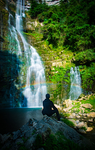 Young man travel by waterfall