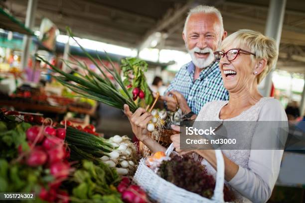 Smiling Senior Couple Holding Basket With Vegetables At The Market Stock Photo - Download Image Now