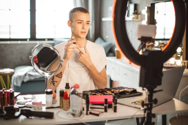 istock Young male makeup artist vlogging at home 1051731684