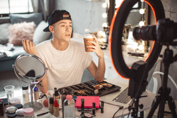 istock Young male makeup artist vlogging at home 1051731730