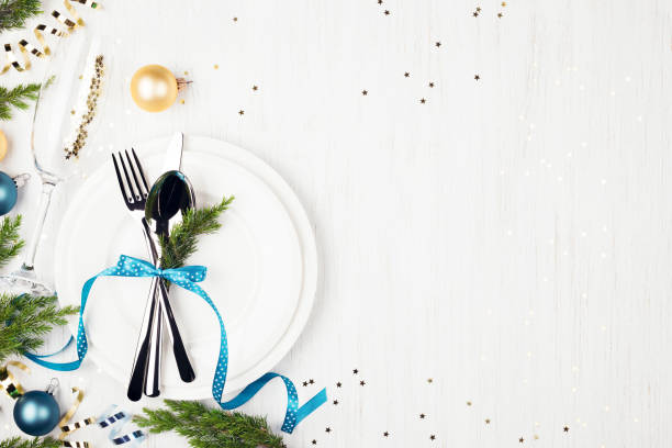 istock Christmas table setting with blue and golden decorations and evergreens. 1051732602