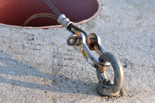 close-up of a shackle connecting a wire rope with metal ring in a concrete block