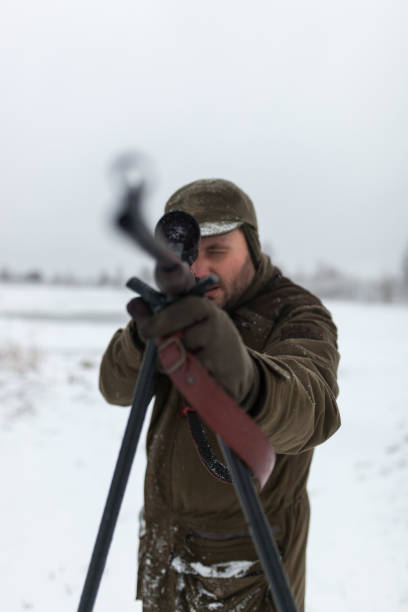 istock Hunter with the rifle in winter morning 1051739524