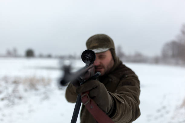 istock Hunter with the rifle in winter morning 1051739592