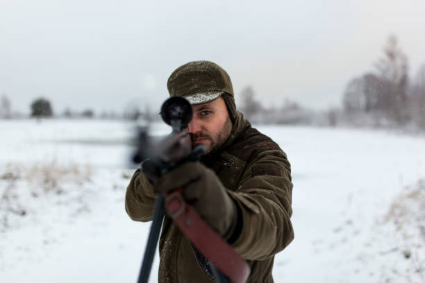istock Hunter with the rifle in winter morning 1051739598