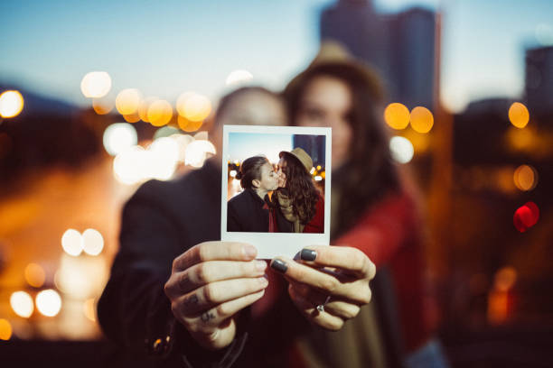 junges paar zeigt sofortige porträt an der kamera - polaroid transfer fotos stock-fotos und bilder