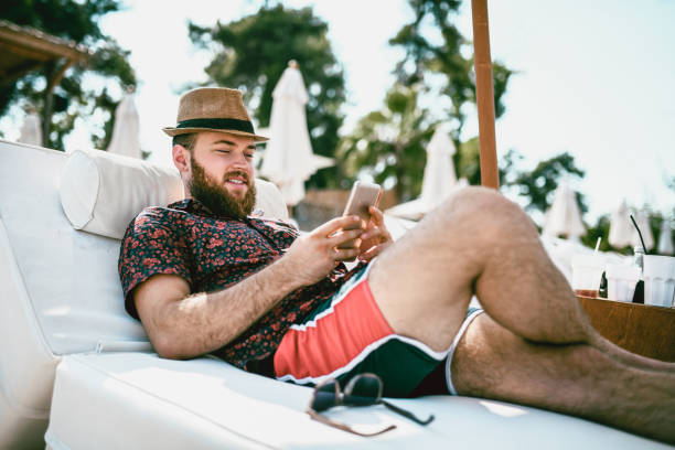 istock Bearded Male Is Making A Video Conference On The Beach 1051743578