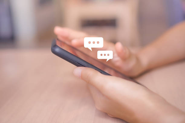 istock Women hand using smartphone typing, chatting conversation in chat box icons pop up. Social media maketing technology concept.Vintage soft color tone background. 1051746208