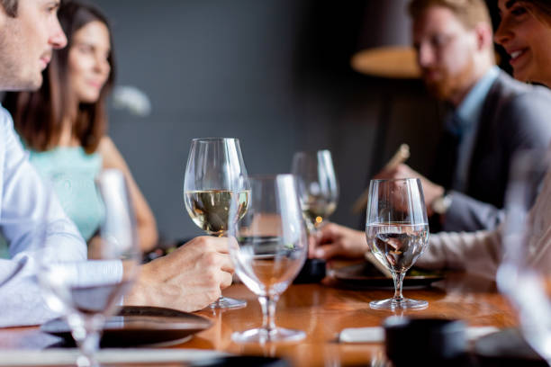 holding half full wineglass on the table - wine glass white wine wineglass imagens e fotografias de stock